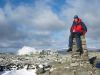 Matt King at the summit of Beinn Narnain with Beinn Ime in the background